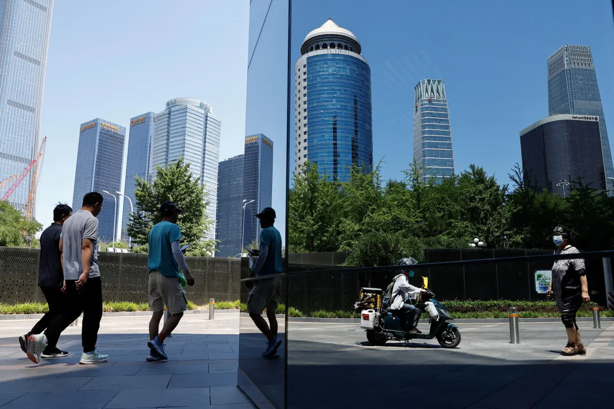 People walk past Beijing's Central Business District