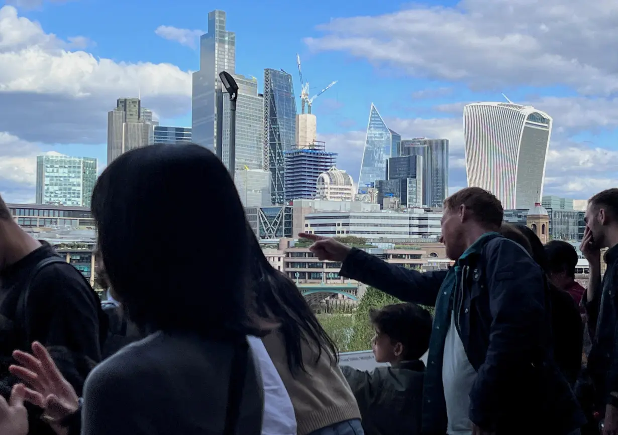 FILE PHOTO: People look at a a view of the City of London skyline in