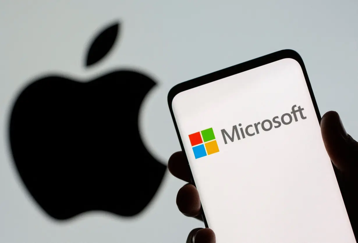 FILE PHOTO: Microsoft logo is seen on the smartphone in front of displayed Apple logo in this illustration taken