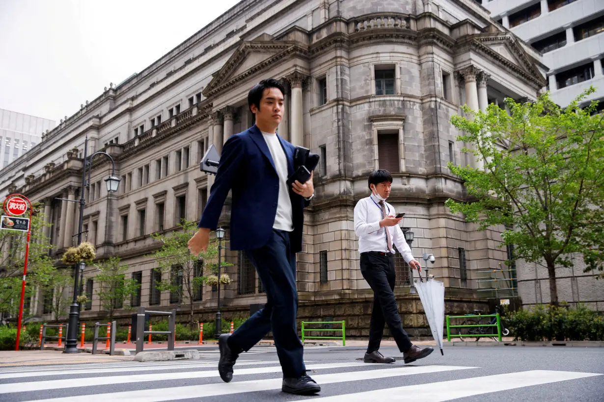 FILE PHOTO: FILE PHOTO: People walk in front of the bank of Japan building in Tokyo