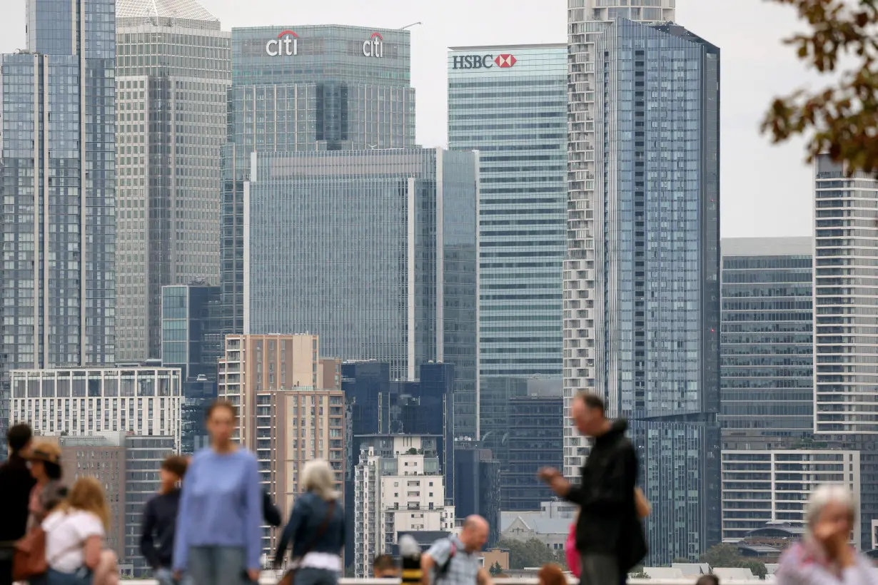 FILE PHOTO: People stand in Greenwich Park with the Canary Wharf financial district in the distance