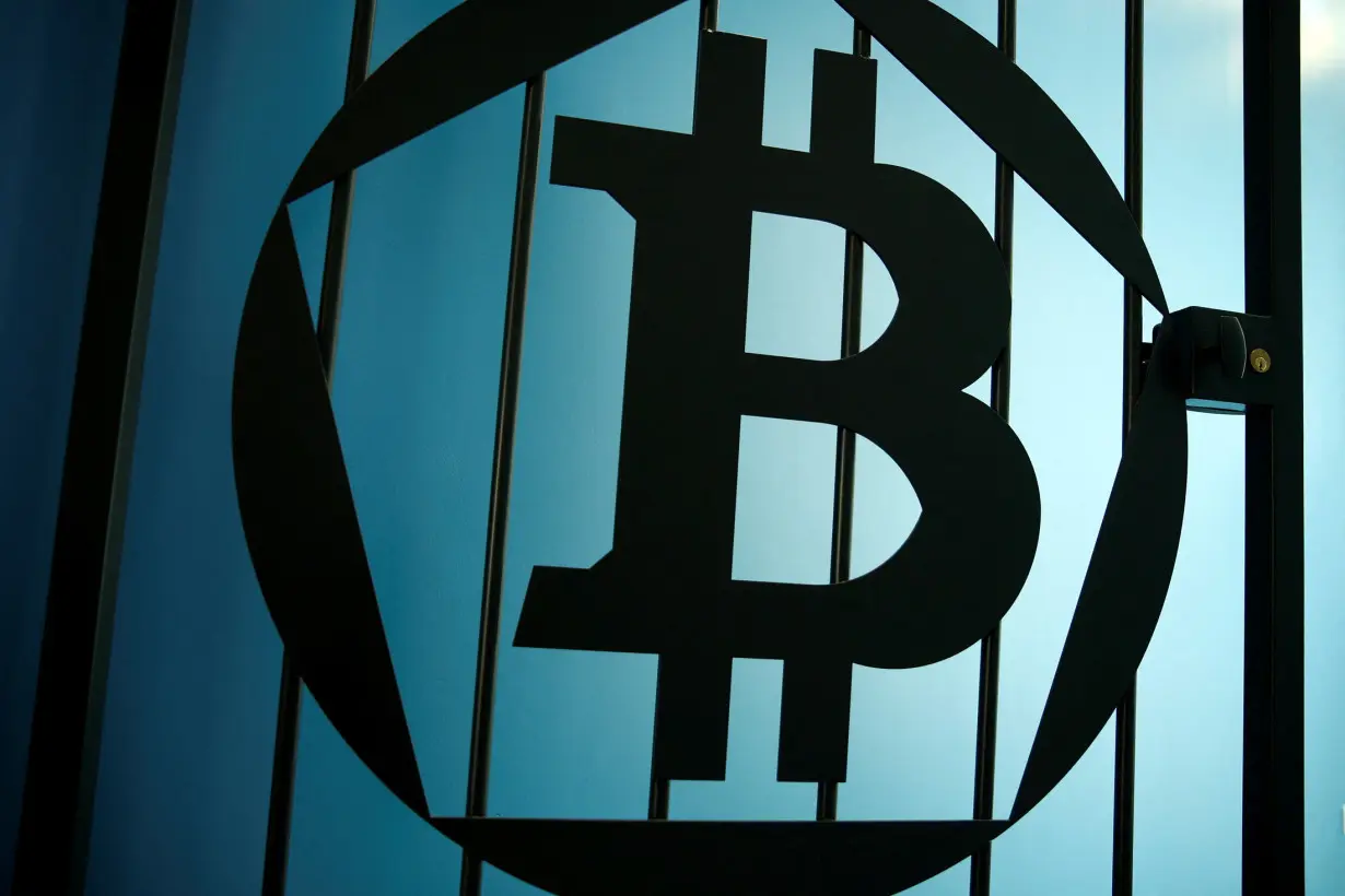 FILE PHOTO: A bitcoin logo is pictured on a door at La Maison du Bitcoin in Paris