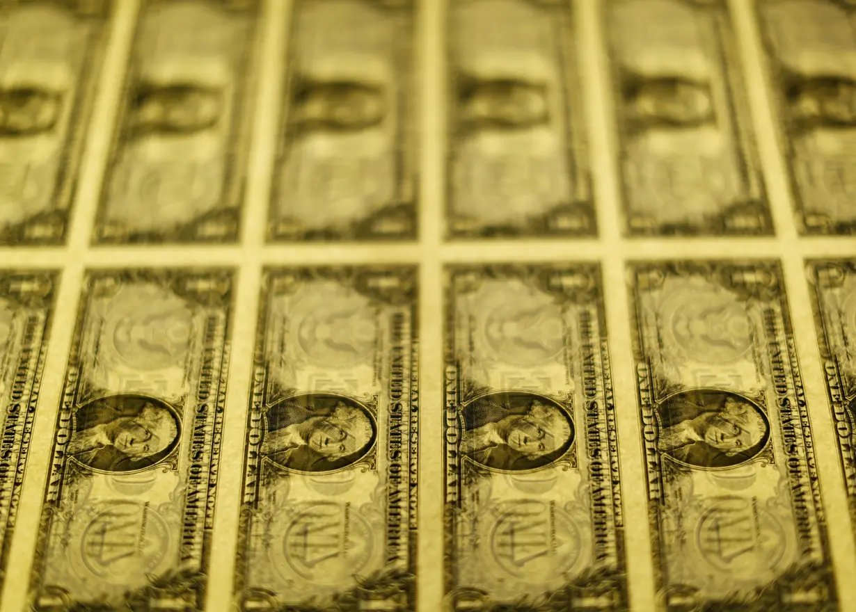 United States one dollar bills are seen on a light table at the Bureau of Engraving and Printing in Washington