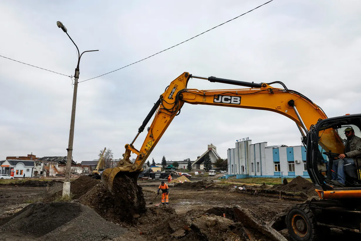 People work next to a railway station, which was heavily damaged on the first months of Russia's attack on Ukraine in the town of Trostianets