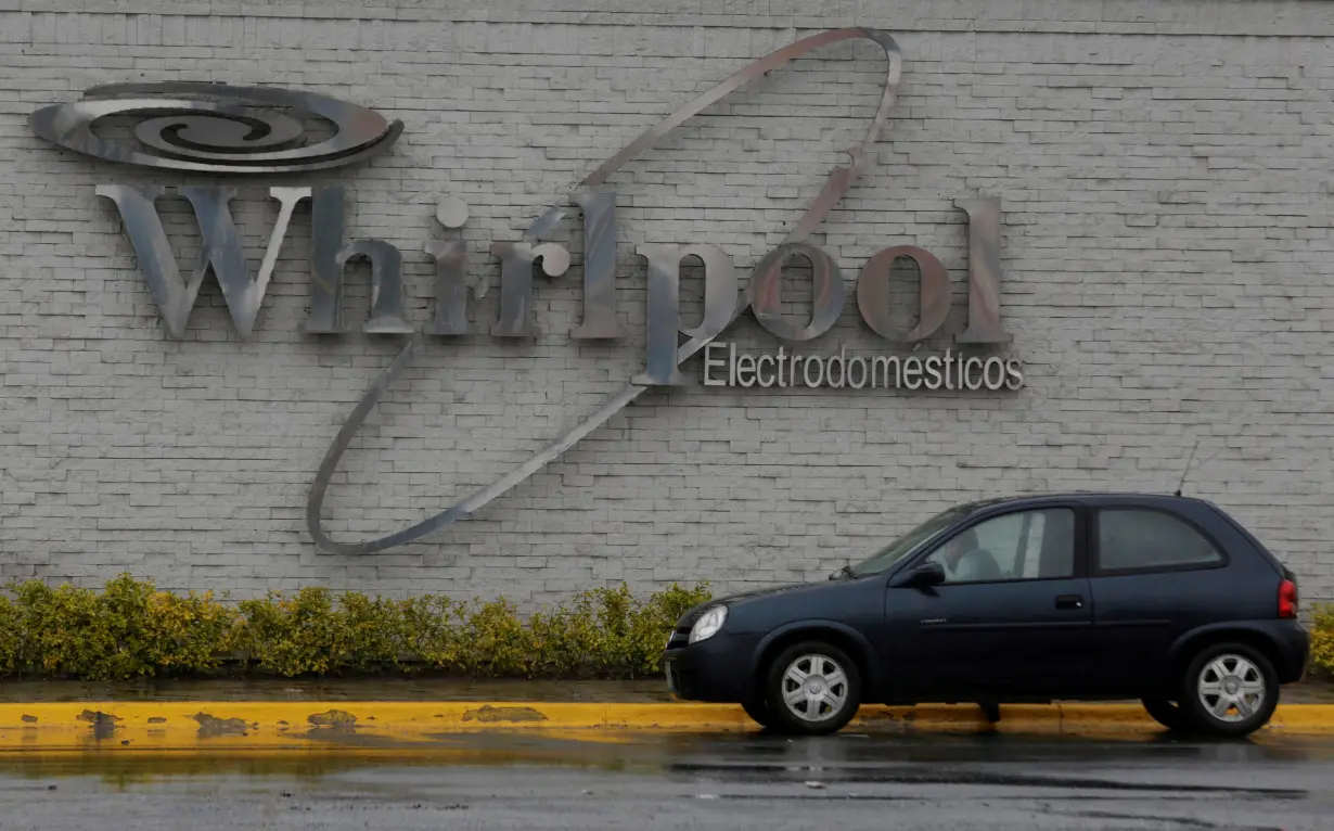 A car parks by the Whirlpool logo is seen at their plant in Apodaca, Monterrey, Mexico