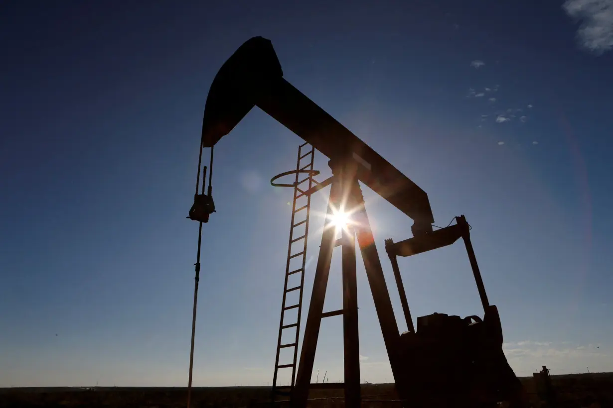 FILE PHOTO: The sun is seen behind a crude oil pump jack in the Permian Basin in Texas