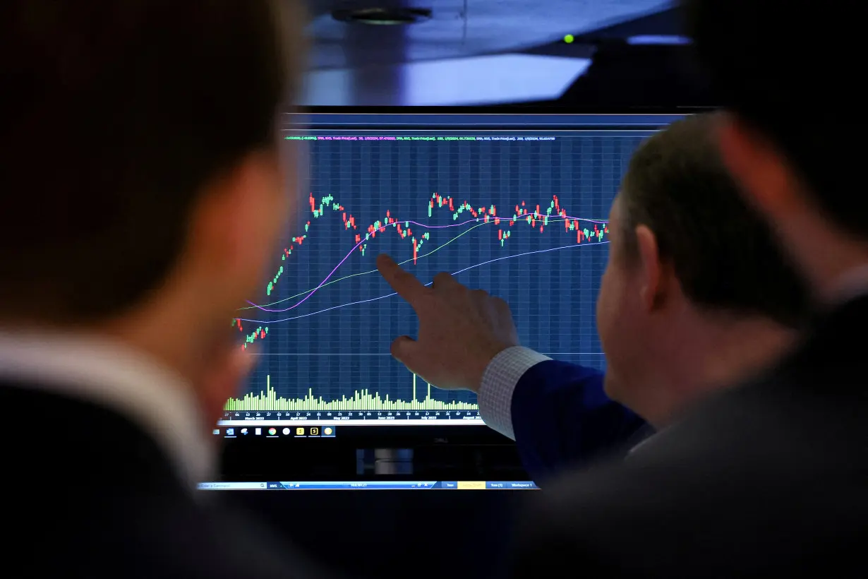 FILE PHOTO: Traders work on the floor of the NYSE in New York