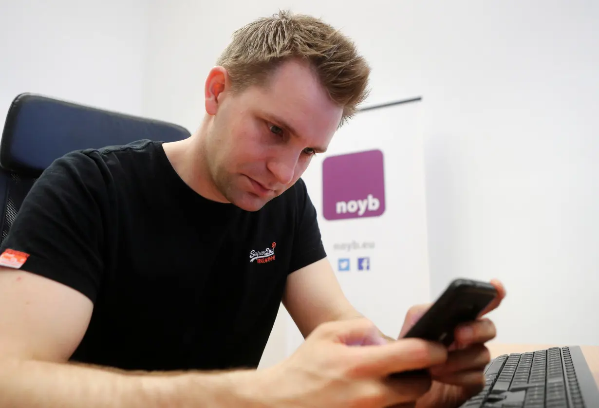 Austrian lawyer and privacy activist Schrems checks his mobile phone in his office in Vienna