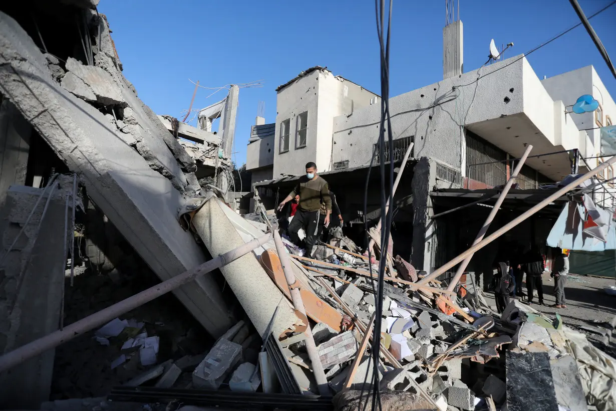 Palestinians inspect the site of an Israeli strike in Deir Al-Balah