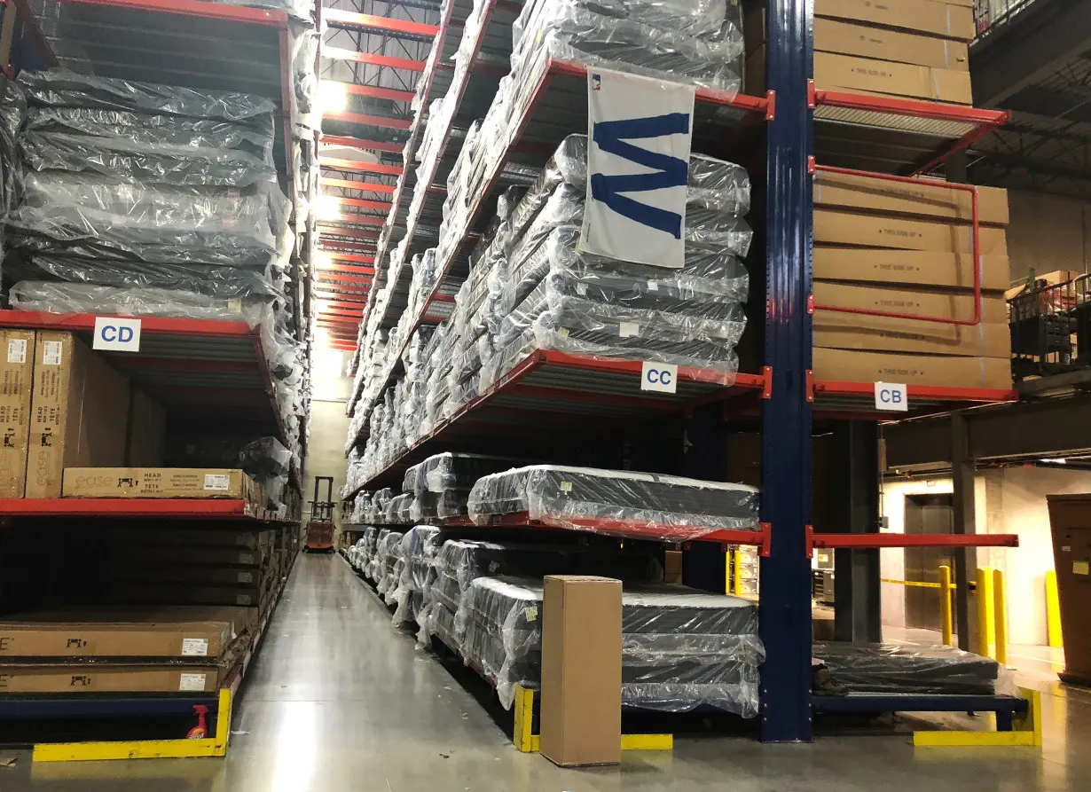 Warehouse workers deal with inventory stacked up to the ceiling at an ABT Electronics Facility in Glenview