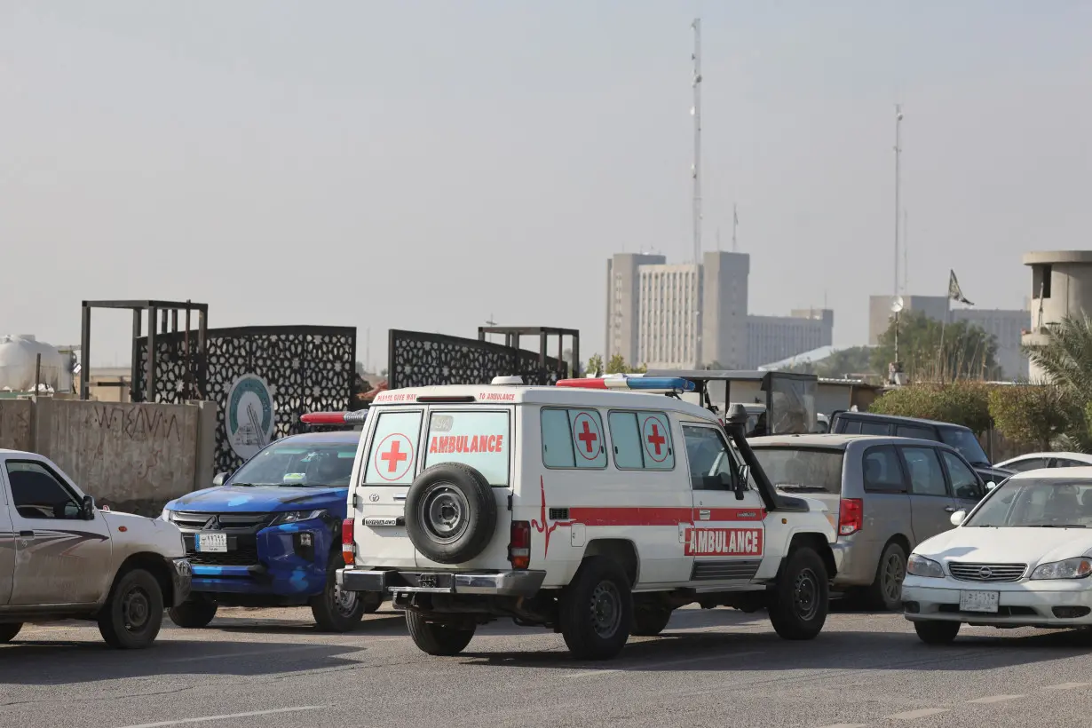 Iraqi ambulance is parked next to a police vehicle at a street after an attack by a drone strike on an Iran-backed militia headquarters in Baghdad