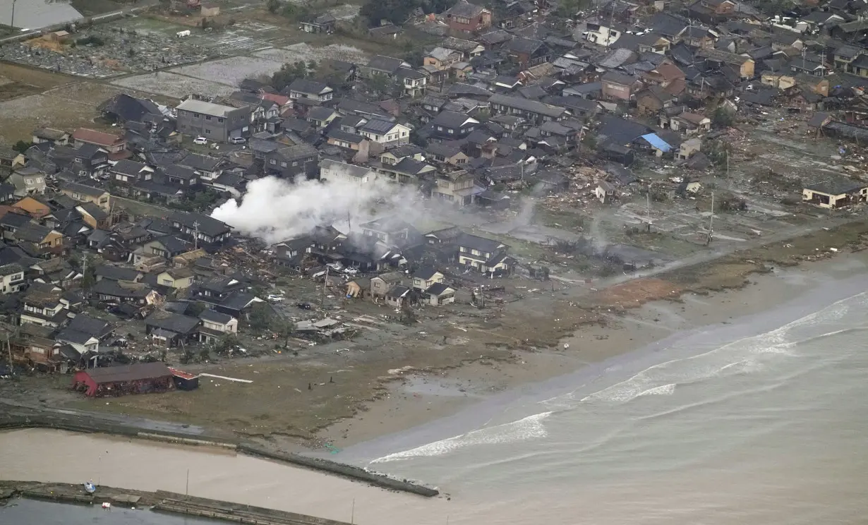 Smoke rises from the destroyed site caused by an earthquake at a residential area in Suzu