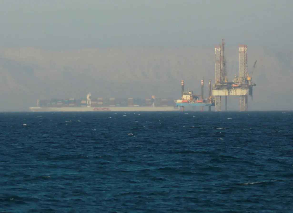 FILE PHOTO: Container ship crosses an oil platform at the Gulf of Suez towards the Red Sea