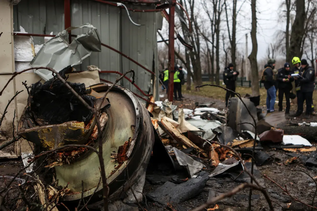 Firefighter extinguishes remains of an unidentified missile, which Ukrainian authorities claimed to be made in North Korea, at a site of a Russian strike in Kharkiv