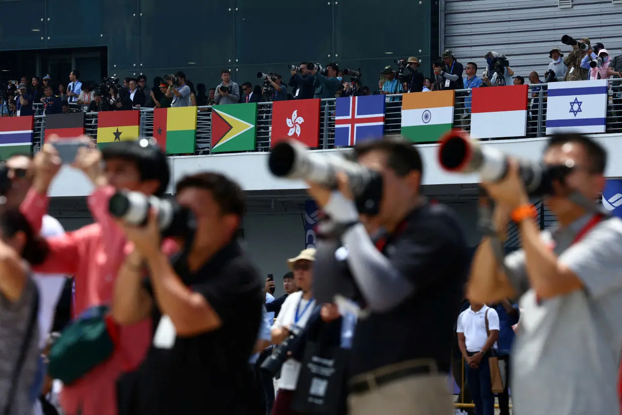 FILE PHOTO: People take photos during an aerial display at the Singapore Airshow at Changi Exhibition Centre in Singapore