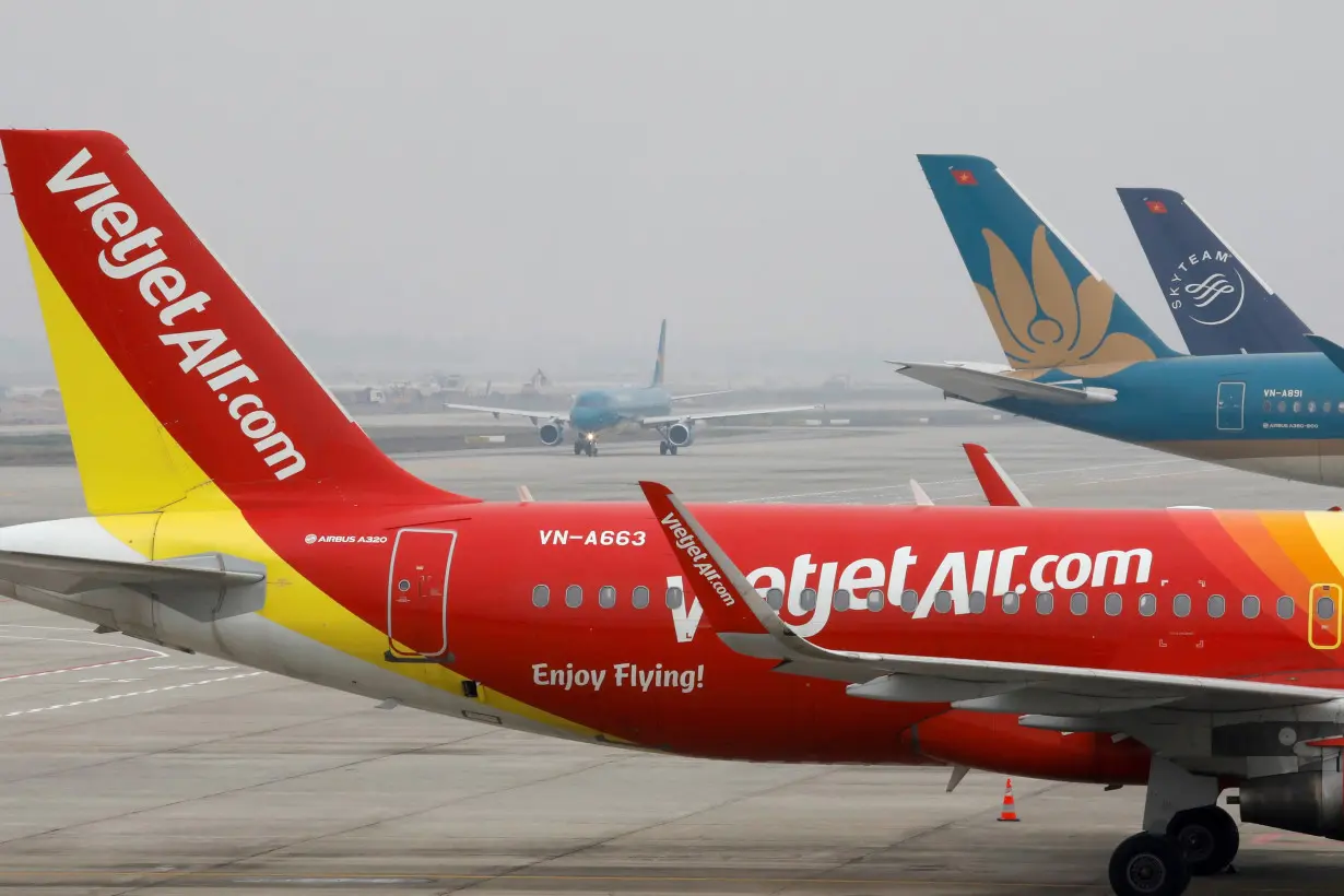 FILE PHOTO: Aircraft of the national flag carrier Vietnam Airlines taxis between a Vietjet aircraft at Noi Bai airport in Hanoi