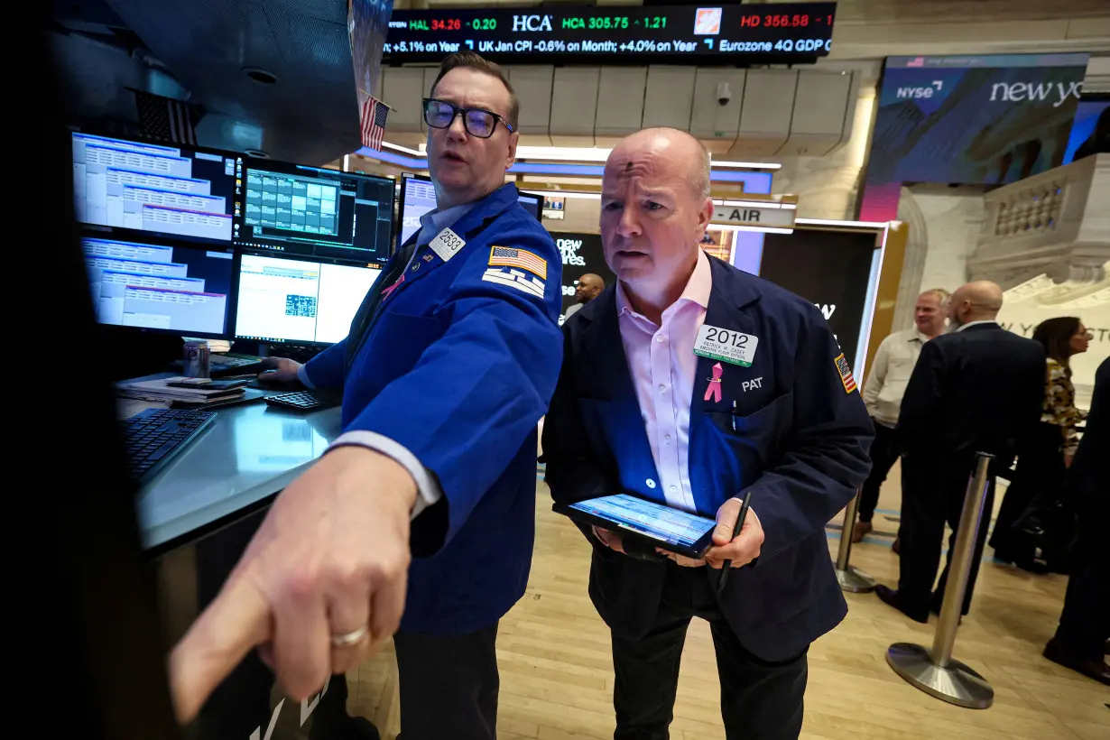 FILE PHOTO: Traders work on the floor of the NYSE in New York