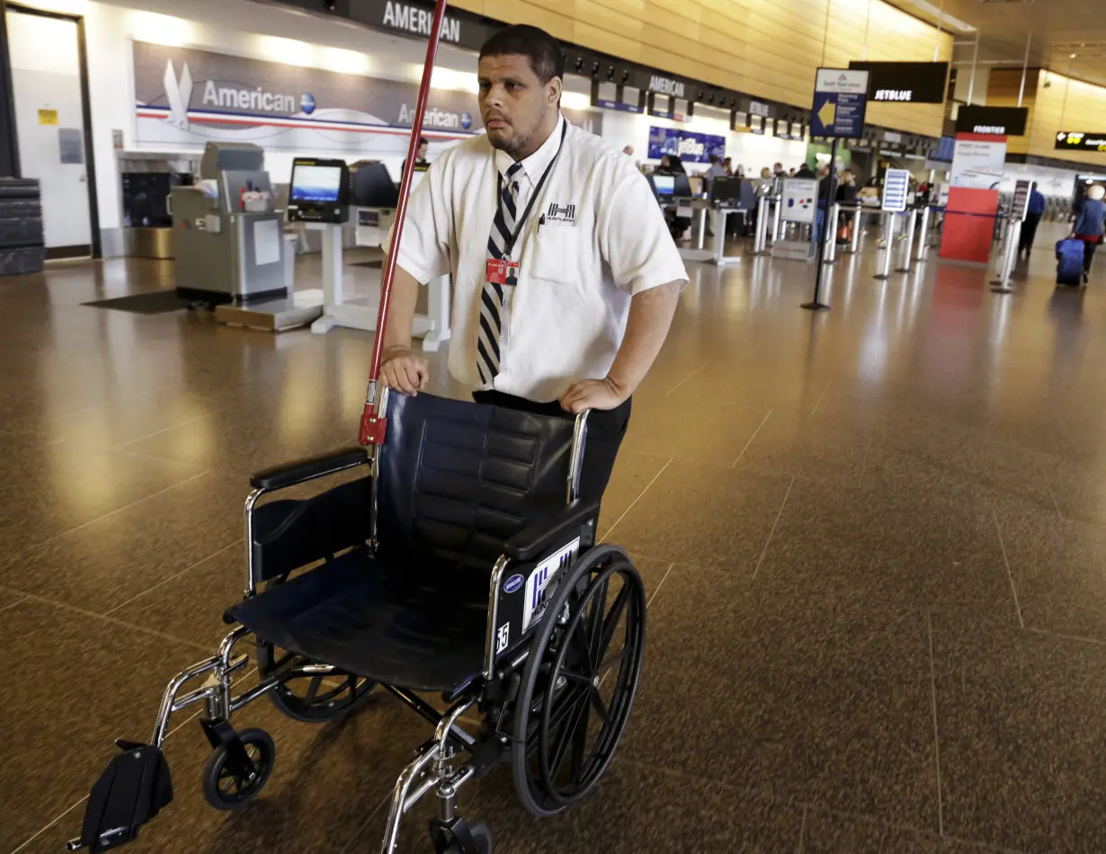 Special services worker Baker pushes a wheelchair to assist an elderly traveler at Seattle-Tacoma International Airport
