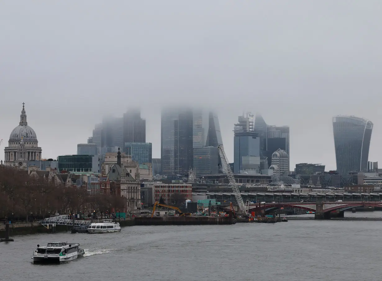 Low cloud and mist shroud the top of skyscrapers in the City of London financial district