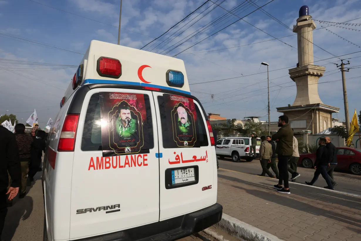 FILE PHOTO: Ambulances carry the coffins of Iraqi Shi'ite armed group members who were killed by a U.S. air strike in al-Qaim, during a funeral in Baghdad