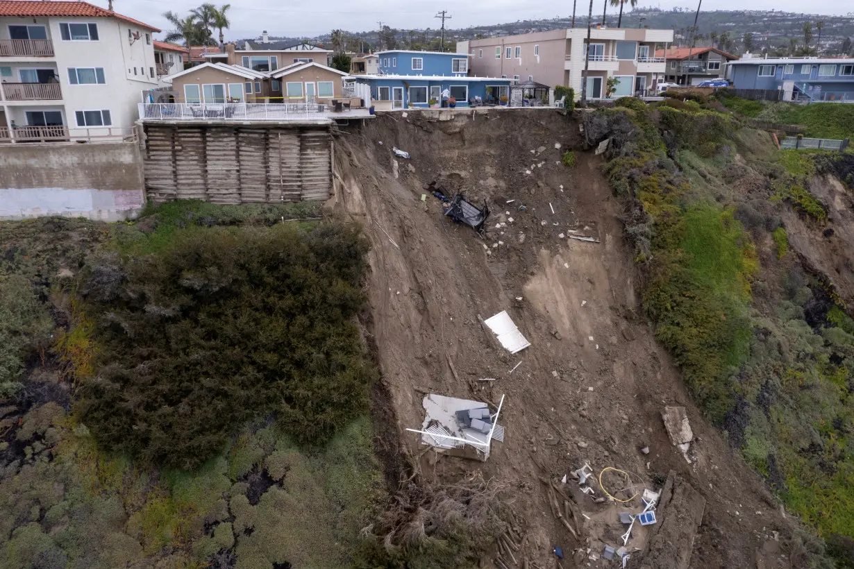 FILE PHOTO: A backyard pool hangs on cliffside after torrential rains hits California beachtown