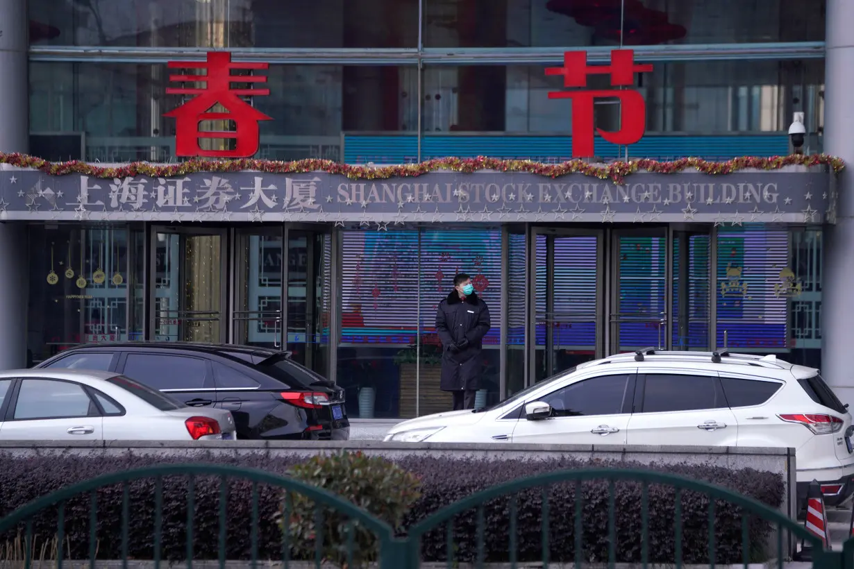 FILE PHOTO: A security guard stands at the Shanghai Stock Exchange building at the Pudong financial district in Shanghai