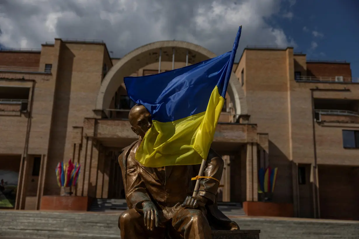 Ukrainian national flag is attached on a monument to widely known Ukrainian poet Taras Shevchenko at a square in front of a local administration headquarter in the Balakliia town