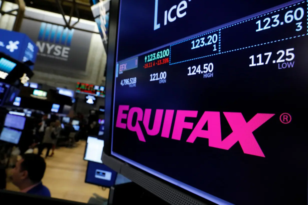 Trading information and the company logo are displayed on a screen where the stock is traded on the floor of the NYSE in New York