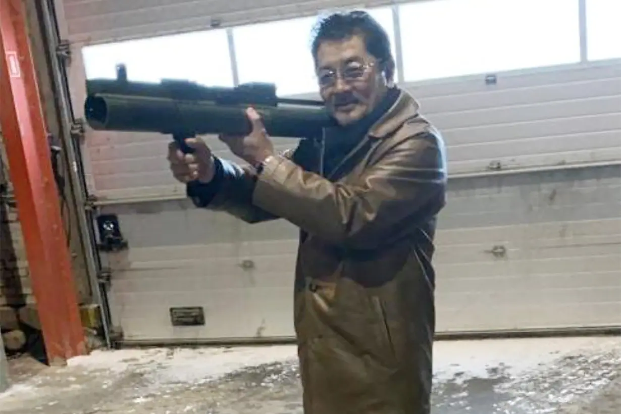 Takeshi Ebisawa poses with a rocket launcher during a meeting with an informant at a warehouse in Copenhagen