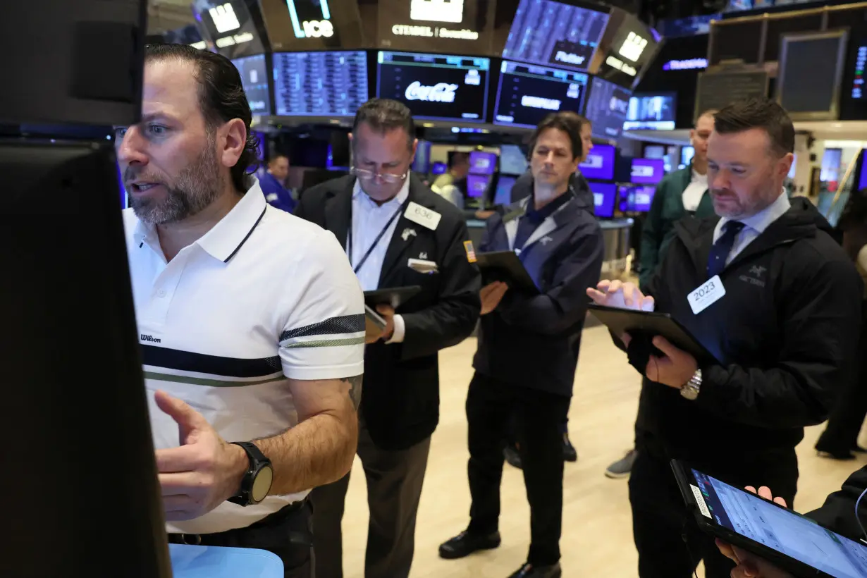 FILE PHOTO: Traders work on the floor of the NYSE in New York