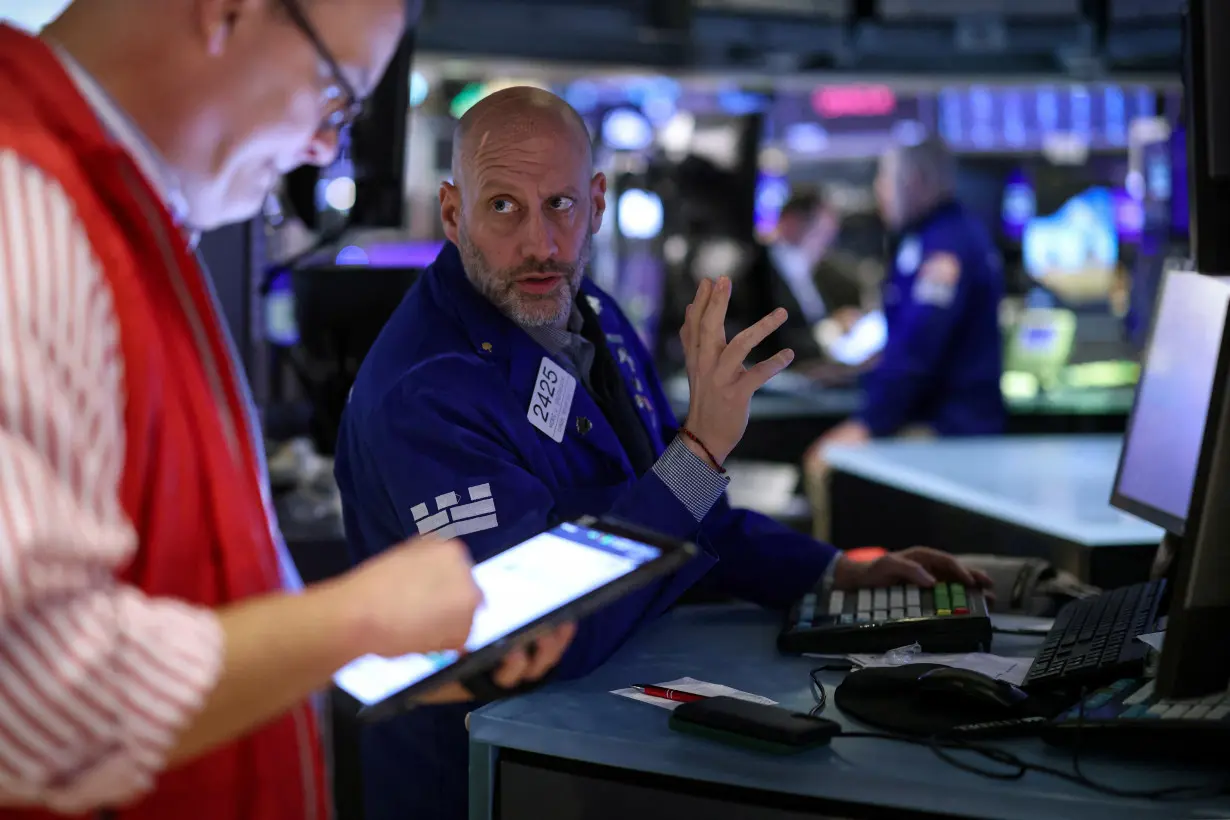 FILE PHOTO: Traders work on the floor of the NYSE in New York