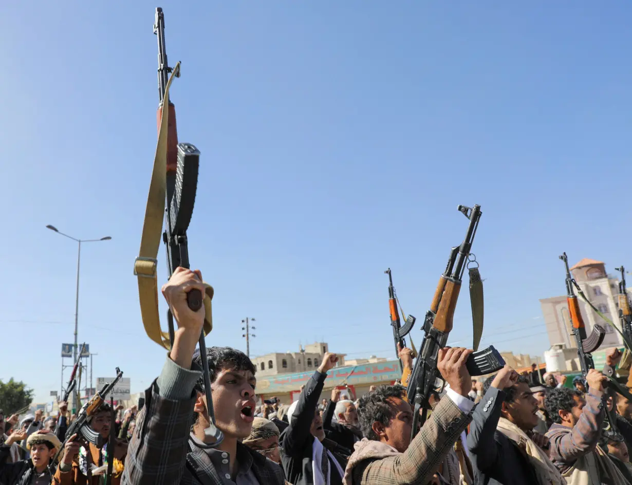 Newly recruited Houthi fighters shout slogans during a ceremony at the end of their training in Sanaa