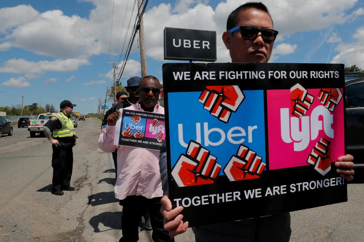 FILE PHOTO: Uber and Lyft drivers protest during a day-long strike outside Uber’s office in Saugus