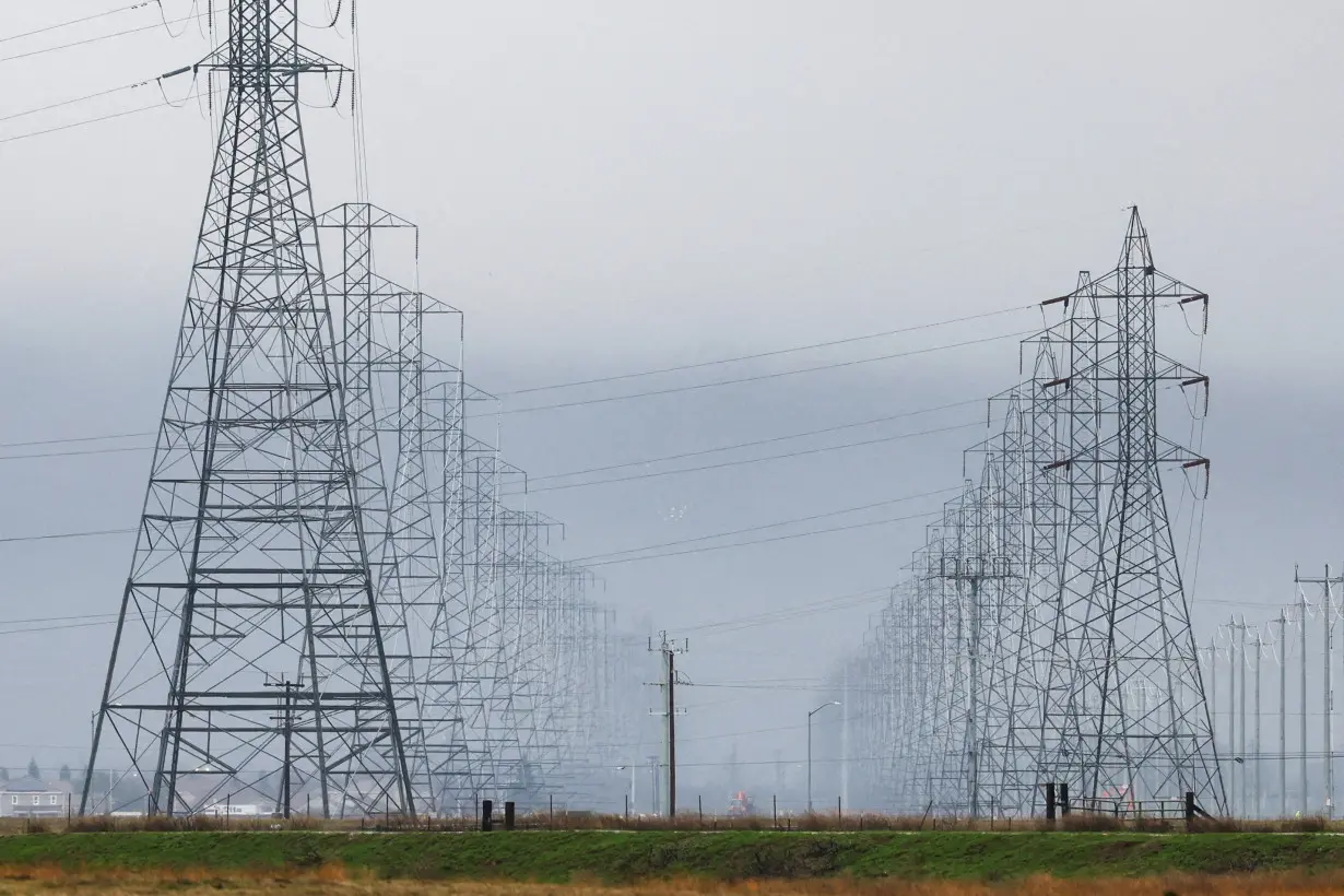 High tension power lines with winter storm clouds behind them are seen in Sacramento County