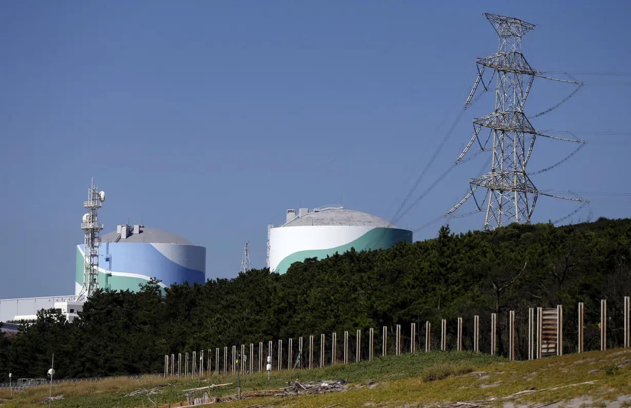 Security personnel stands guard in front of an entrance gate of Kyushu Electric Power's Sendai nuclear power station in Satsumasendai, Japan