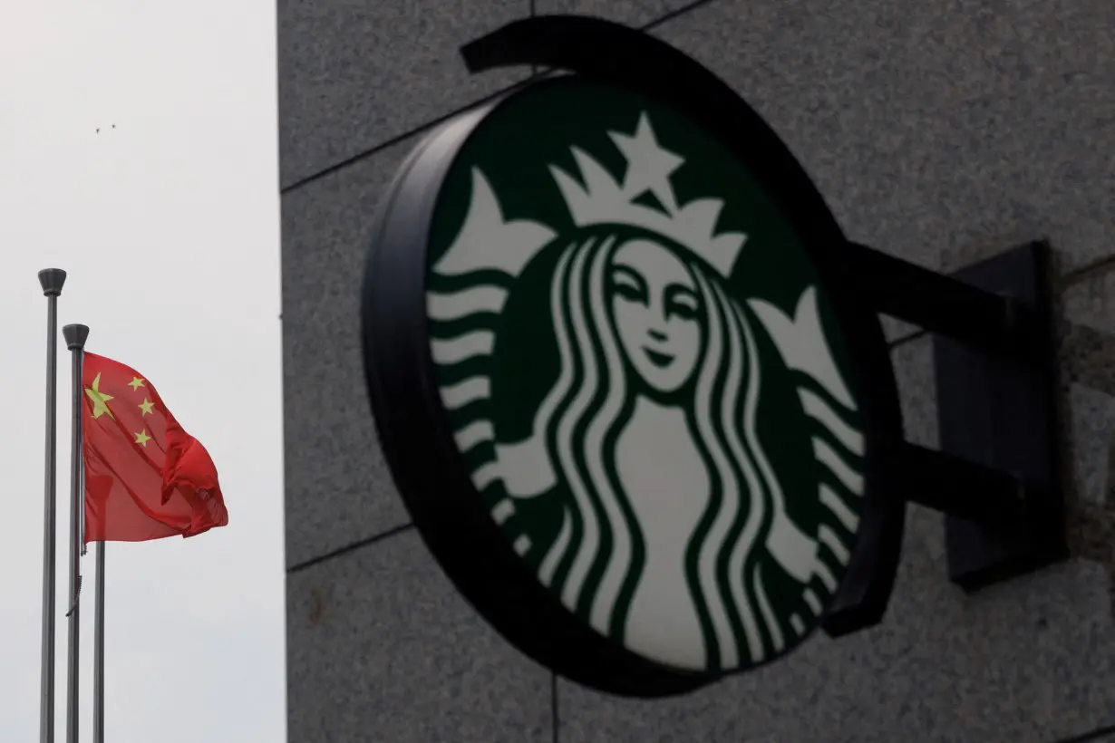 FILE PHOTO: The Chinese flag flies near the Starbucks logo outside a cafe of the coffee chain in Beijing