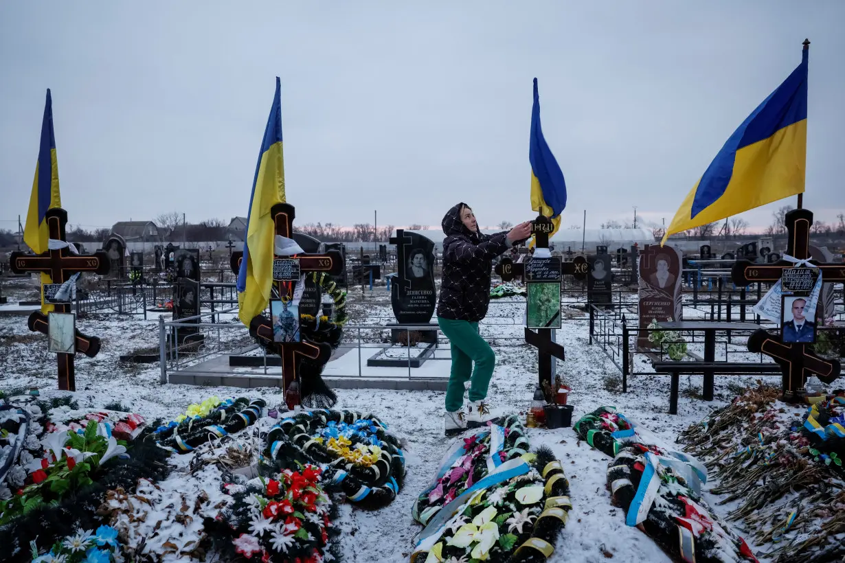 Widow of killed serviceman Aloshkin visits a local cemetery, in Dnipropetrovsk region