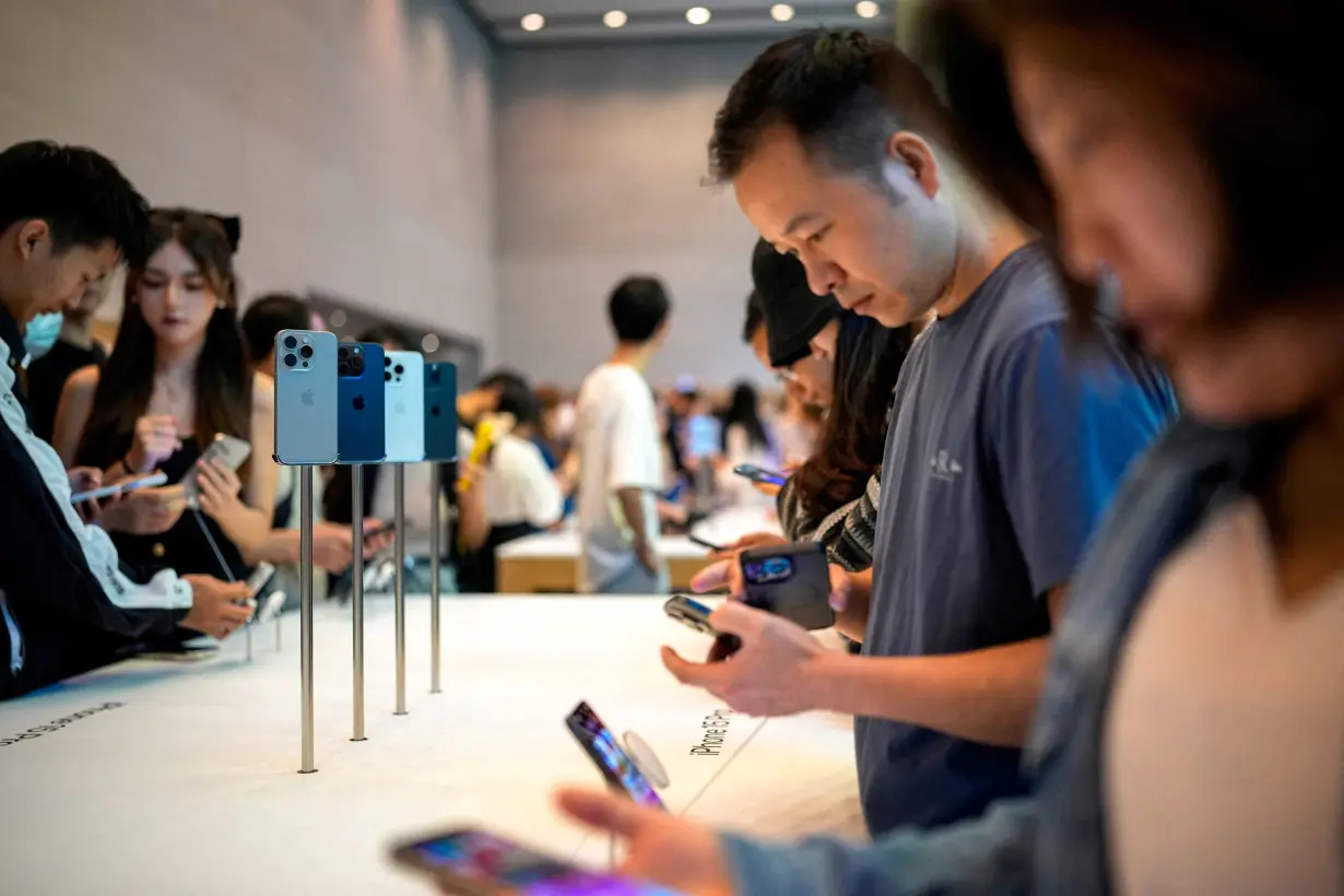 FILE PHOTO: People look at the new iPhone 15 Pro as Apple's new iPhone 15 officially goes on sale across China at an Apple store in Shanghai