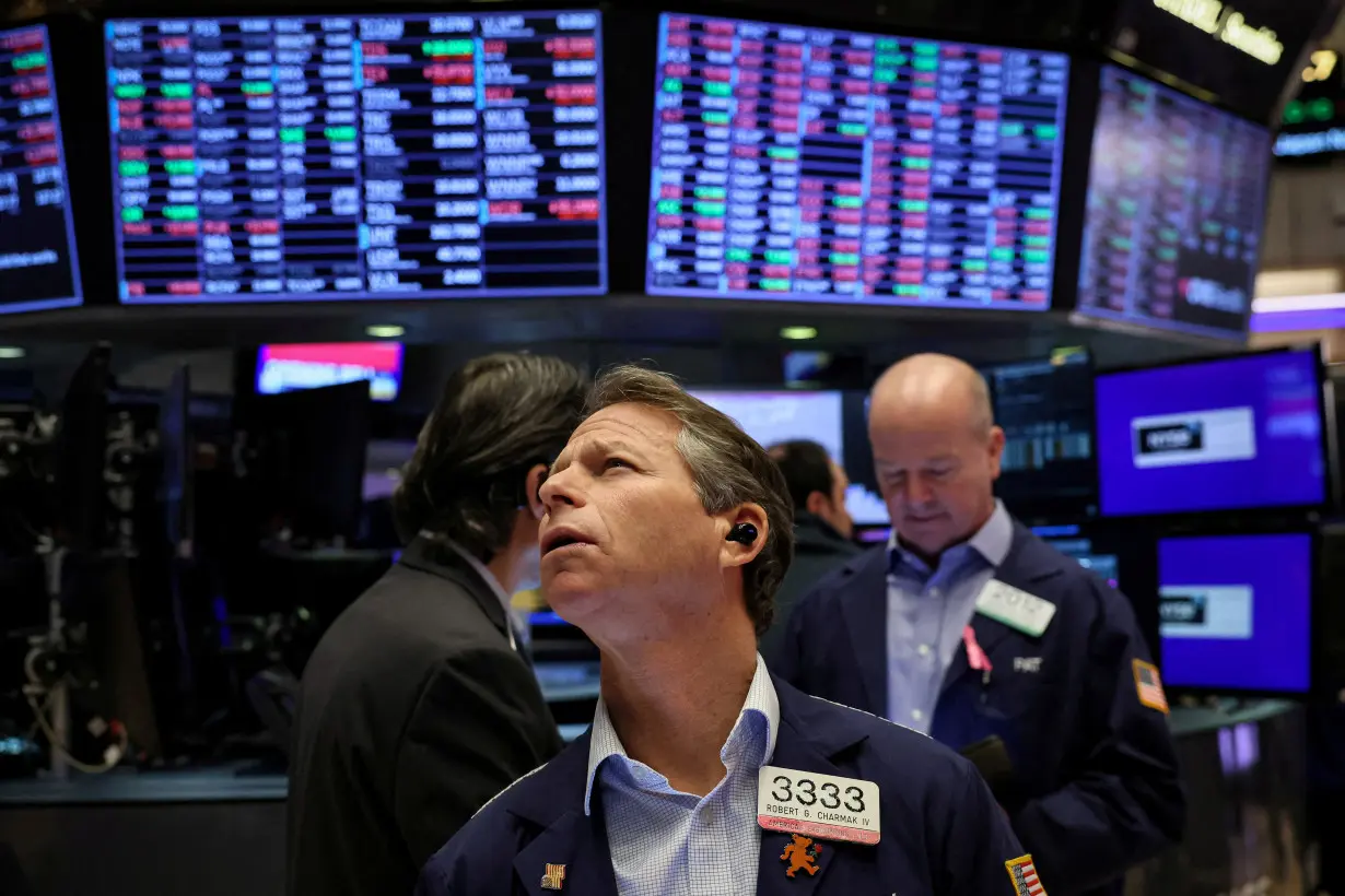 FILE PHOTO: Traders work on the floor of the NYSE in New York