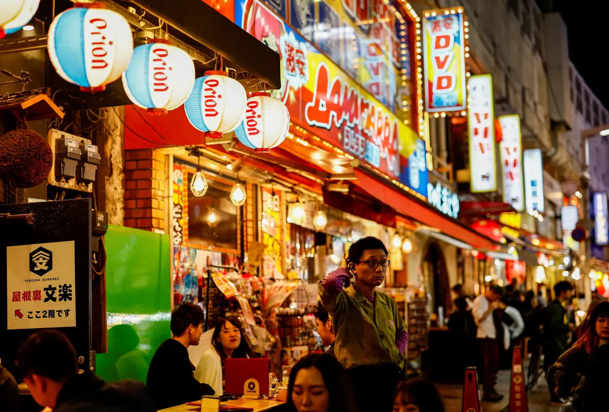 FILE PHOTO: People enjoy drinks and food at izakaya pub restaurants at the Ameyoko shopping district, in Tokyo