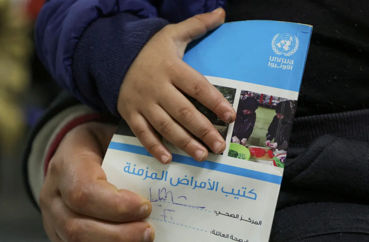 FILE PHOTO: A child holds a booklet as he waits inside a UNRWA health center at Shatila Palestinian refugee camp, in Beirut suburbs