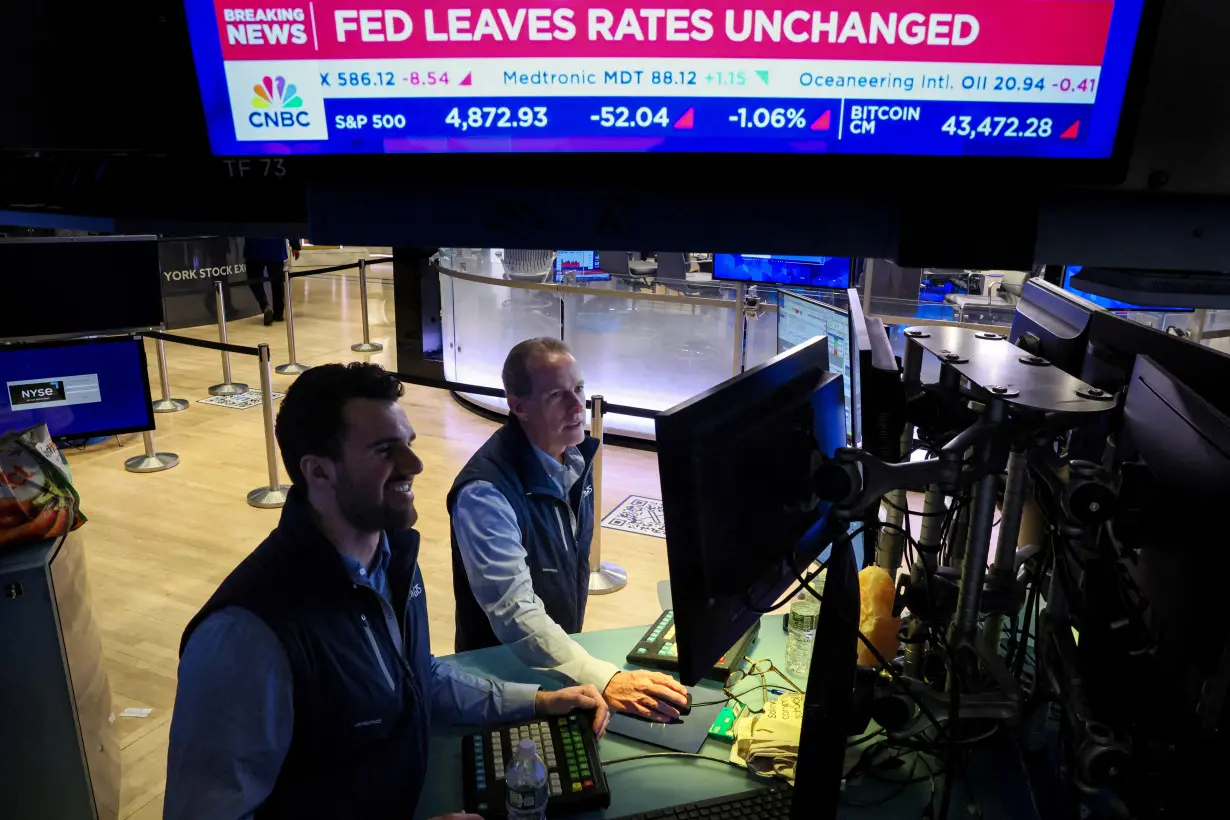 FILE PHOTO: Traders reacts to Fed rate announcement on the floor of the NYSE in New York