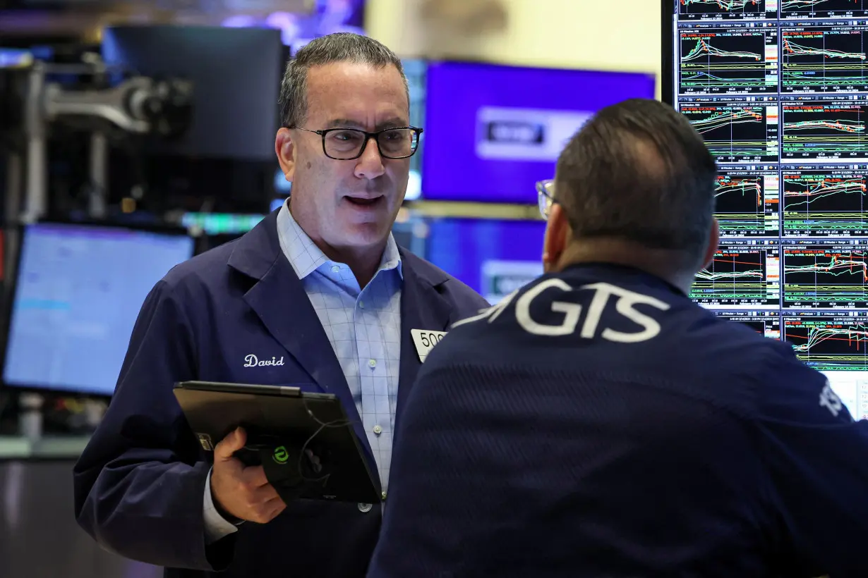 FILE PHOTO: Traders work on the floor of the NYSE in New York