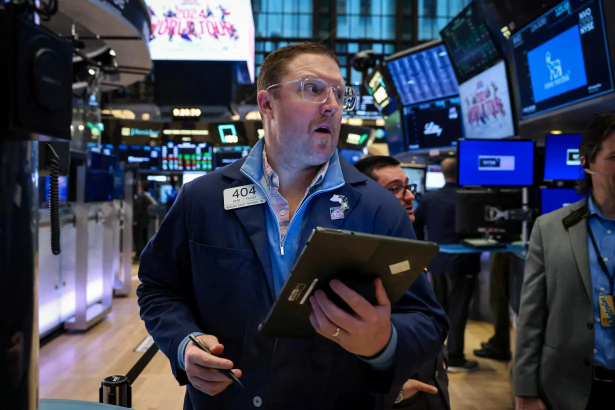 FILE PHOTO: Traders work on the floor of the NYSE in New York