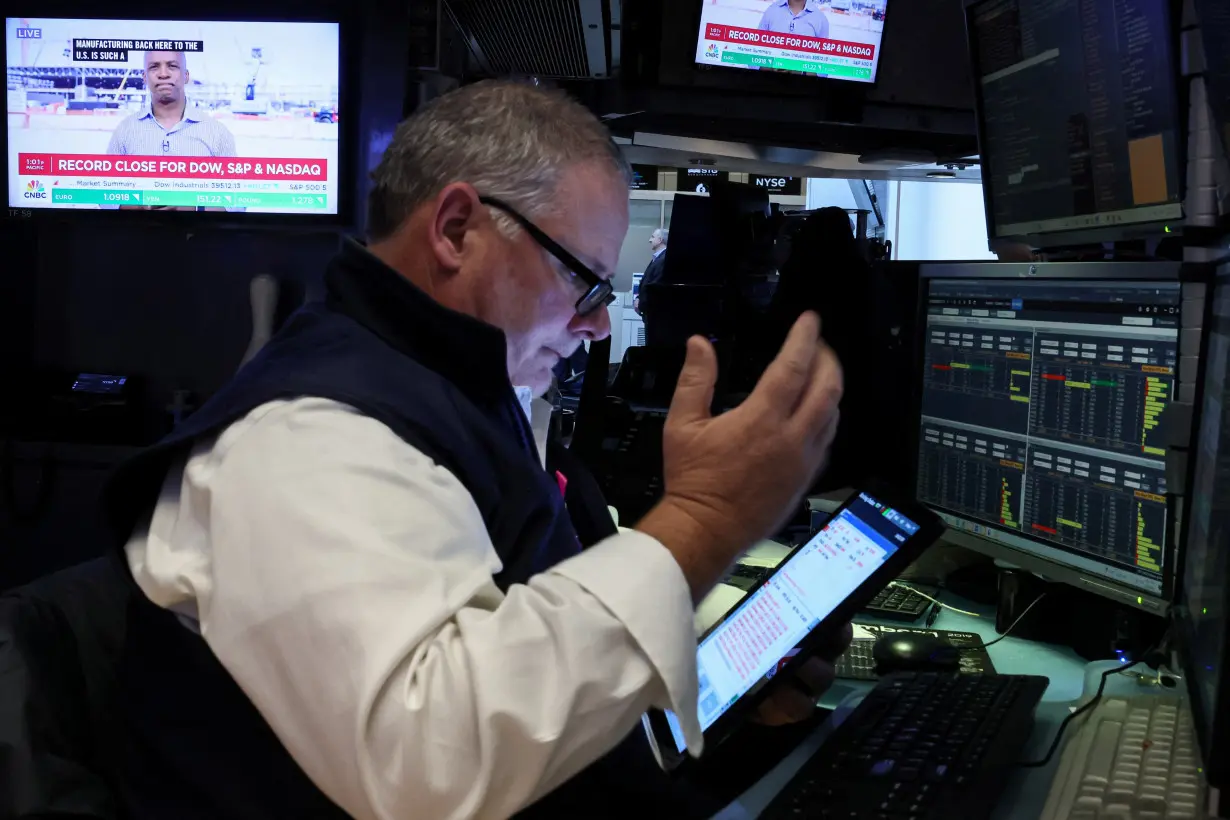 Traders react after the closing bell on the floor of the NYSE in New York