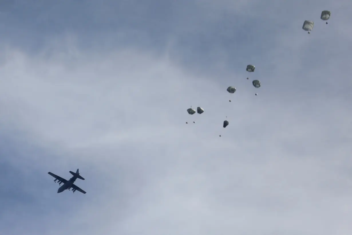 A plane drops aid over Gaza, amid the ongoing the conflict between Israel and Hamas, in Gaza City