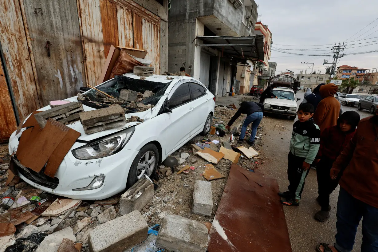 Palestinians inspect the site of an Israeli strike on a house in Rafah