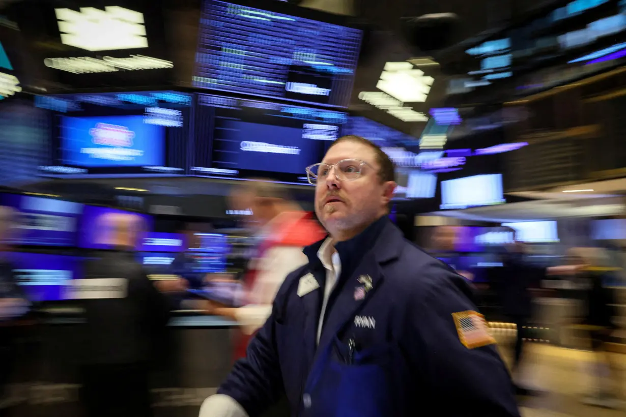 FILE PHOTO: Traders work on the floor of the NYSE in New York