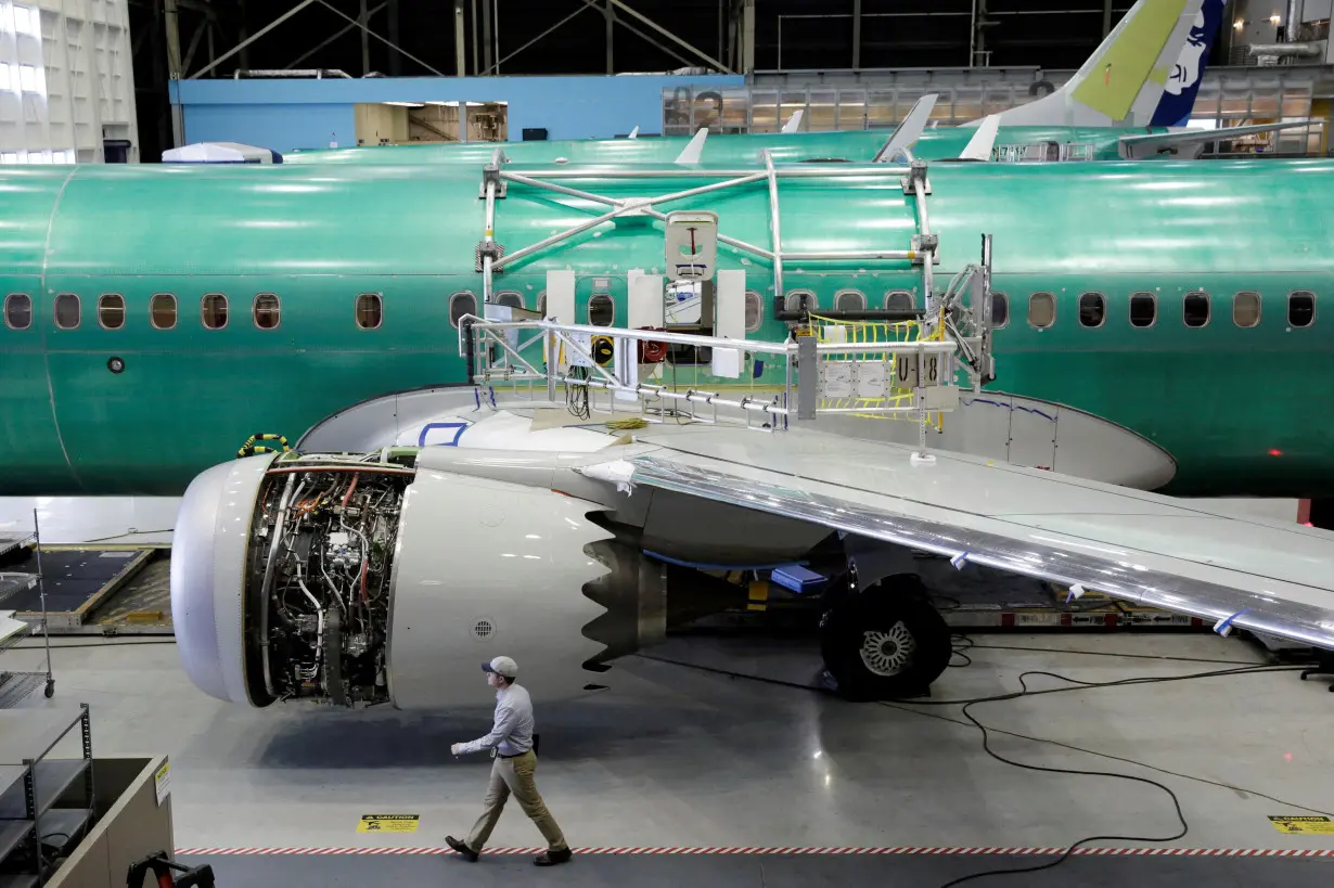 FILE PHOTO: A worker walks past a Boeing 737 MAX-9 under construction at the company's plant in Renton, Washington