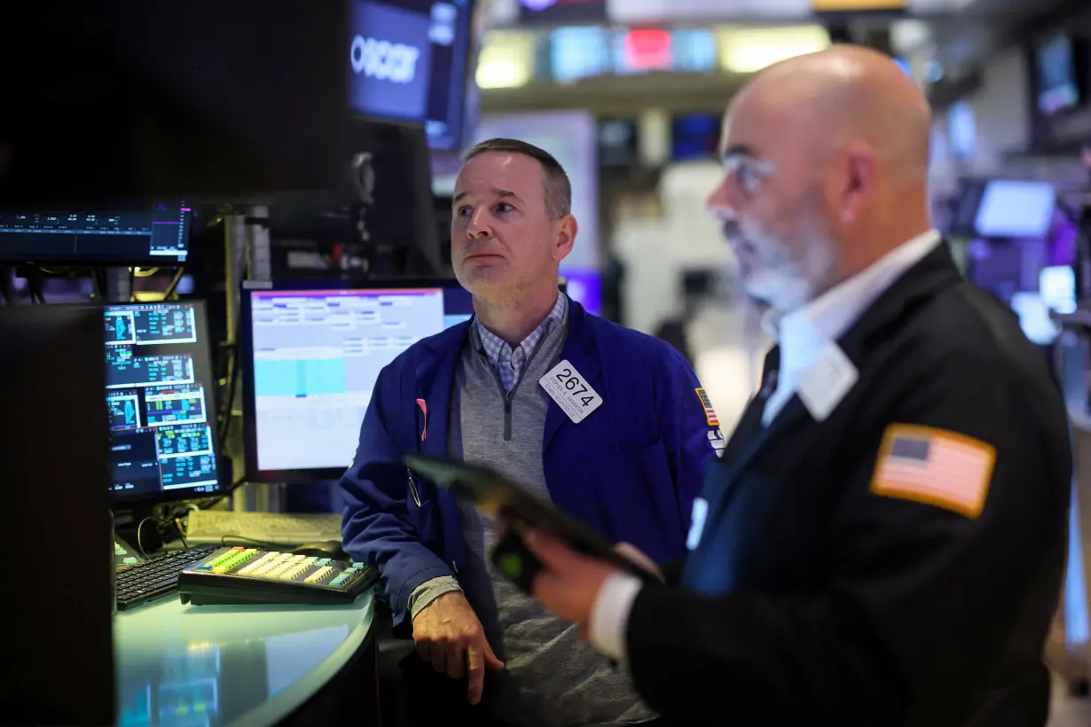 FILE PHOTO: Traders work on the floor of the NYSE in New York